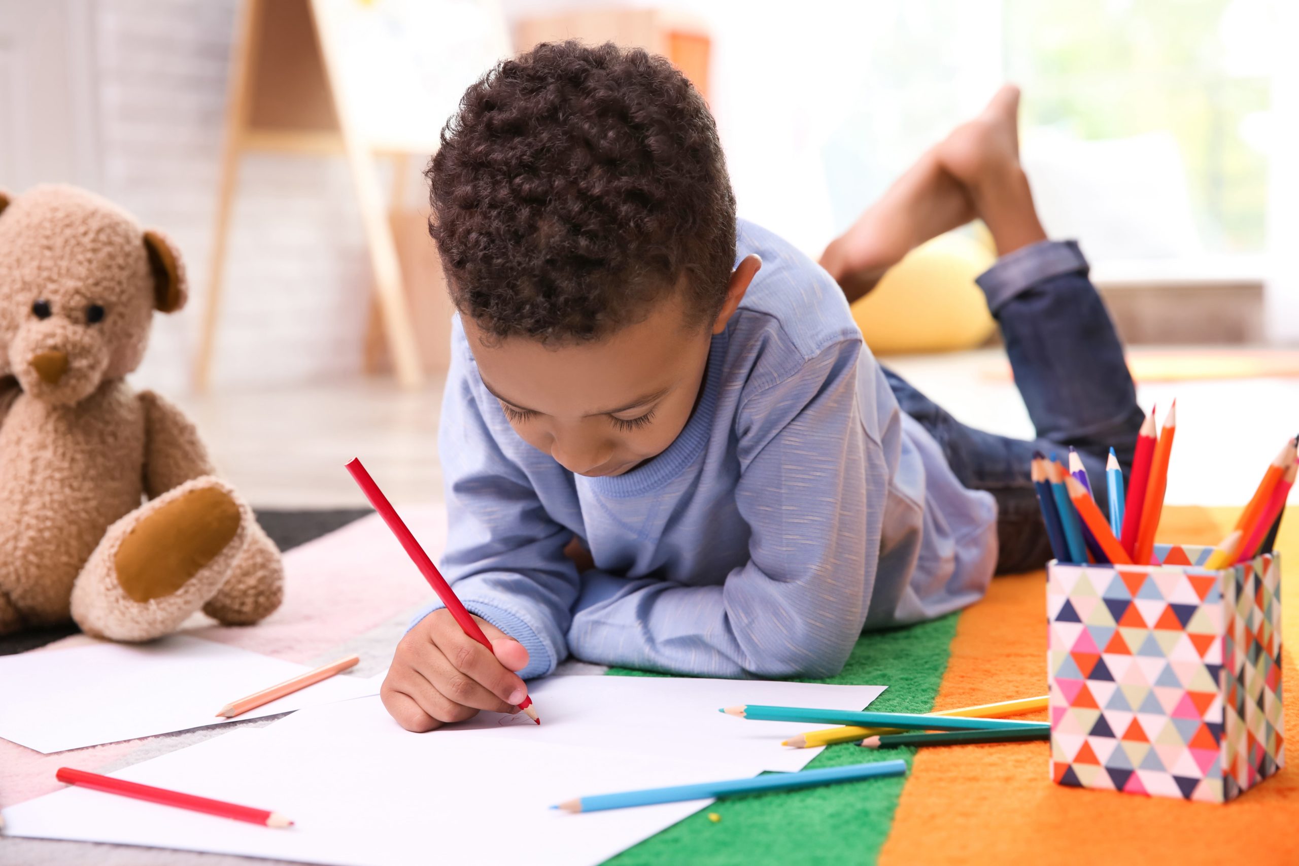 Young boy coloring in a colorful room