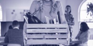 young woman carrying a box of her things after getting fired