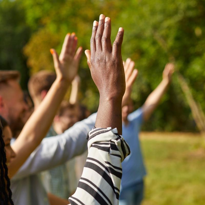 Hands raised while outside near trees