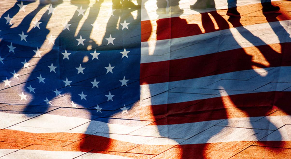 Shadows of people cast across an American flag.