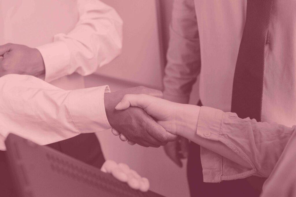 Magenta filtered image of a two people shaking hands